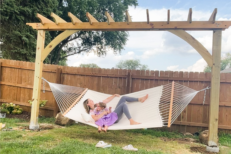 Relaxing on a DIY backyard hammock stand. 